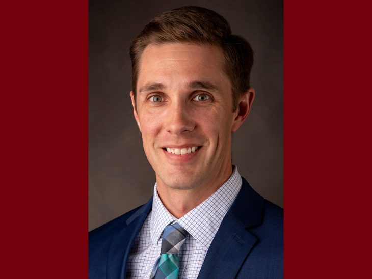 Brandon J. Sheridan headshot on maroon background