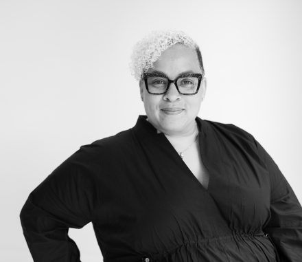 Black and white photo of woman in glasses and black shirt