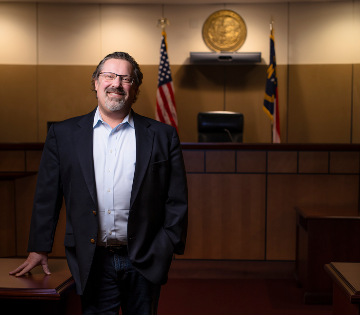 A portrait of Elon University Professor of Law David Levin standing in a courtroom