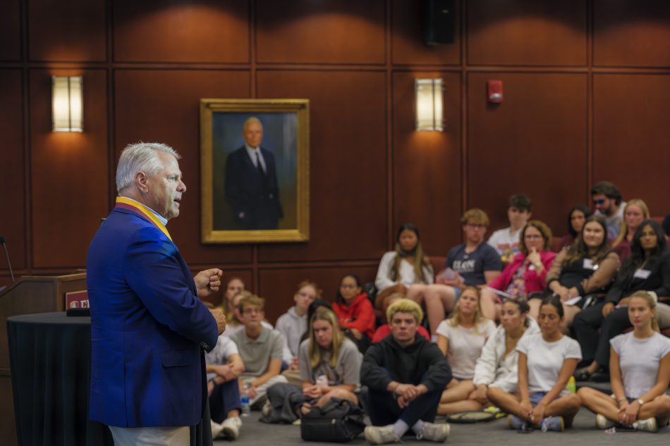 Man in blue speaks in a lecture hall