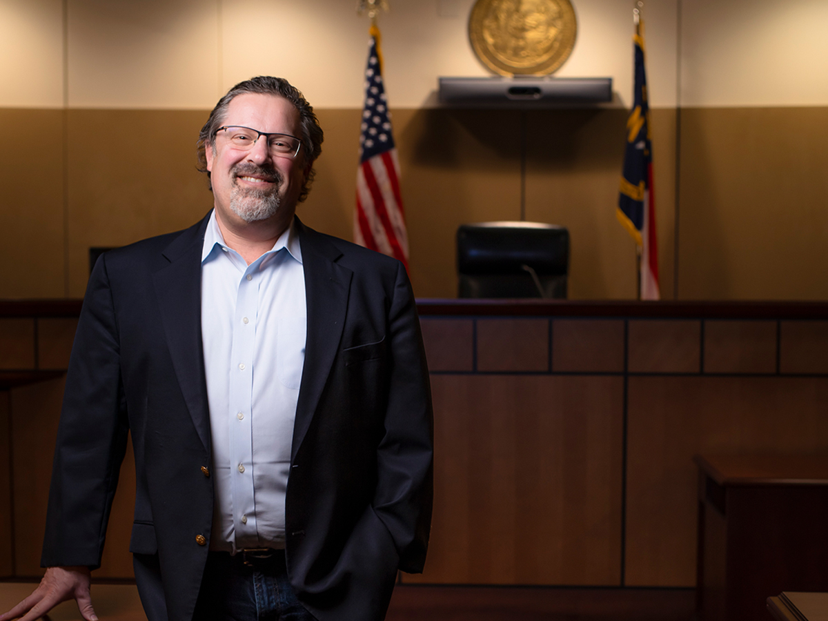 A portrait of Elon University Professor of Law David Levin standing in a courtroom