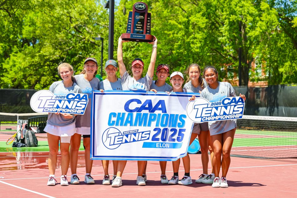 A group of athletes celebrating a victory at the CAA Tennis Championship 2025, holding a trophy and a banner with 'Elon' on it, on a sunny tennis court.
