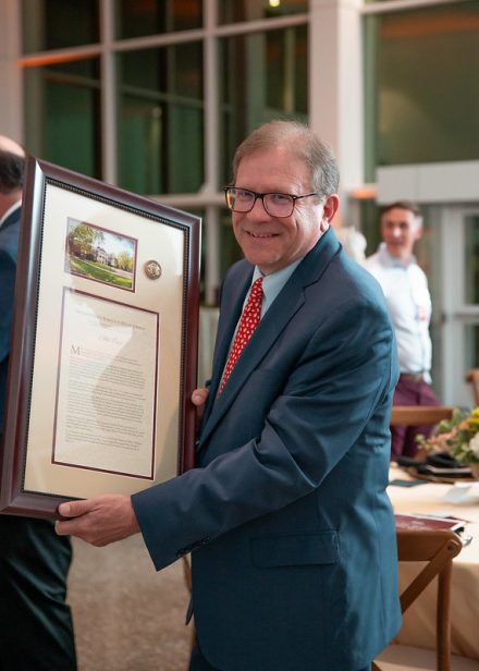 Mike Cross, a recipient of the 2025 Distinguished Alumni Awards, poses with his award after the ceremony on the Elon University campus