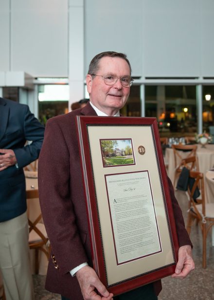 Sam Troy ’67, a recipient of the 2025 Distinguished Alumni Awards, poses with his award after the ceremony on the Elon University campus