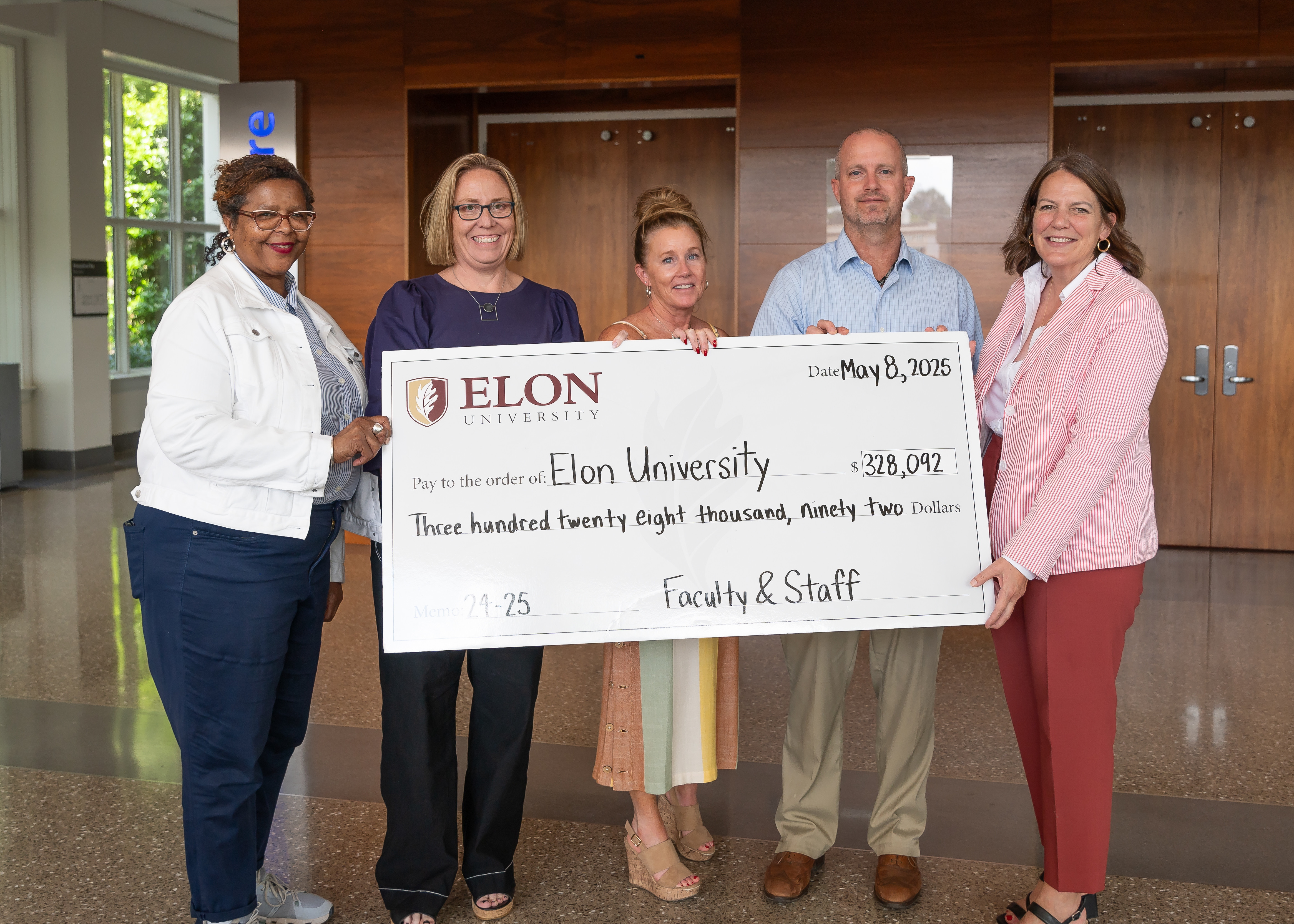 Faculty and staff giving co-chairs present Dr. Book with a check, representing dollars raised in the FY24-25 fiscal year.