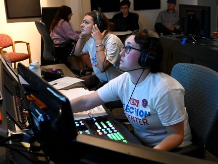 A group of Elon students work in a control room.