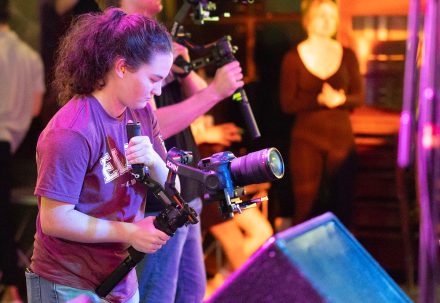 Elon student Christian Kelly '25 holds a camera.