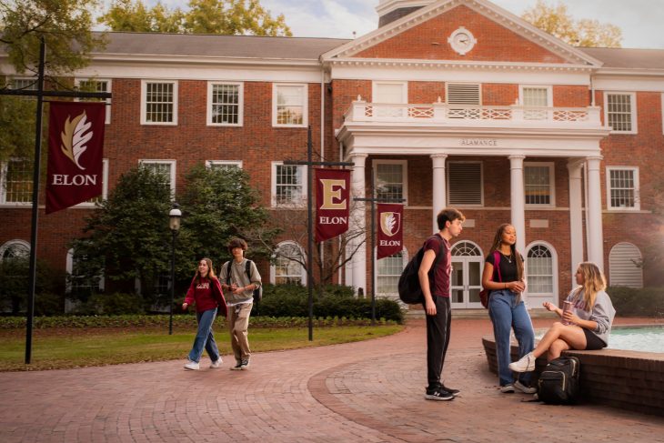 Students walk past and sit around Fonvillen Fountain in front of Alamance Building at Elon University