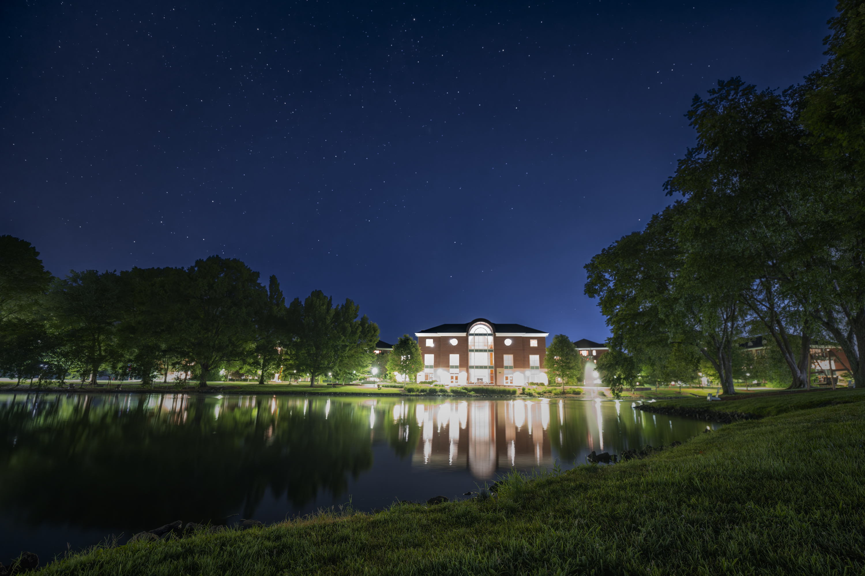 A building across a pond at night