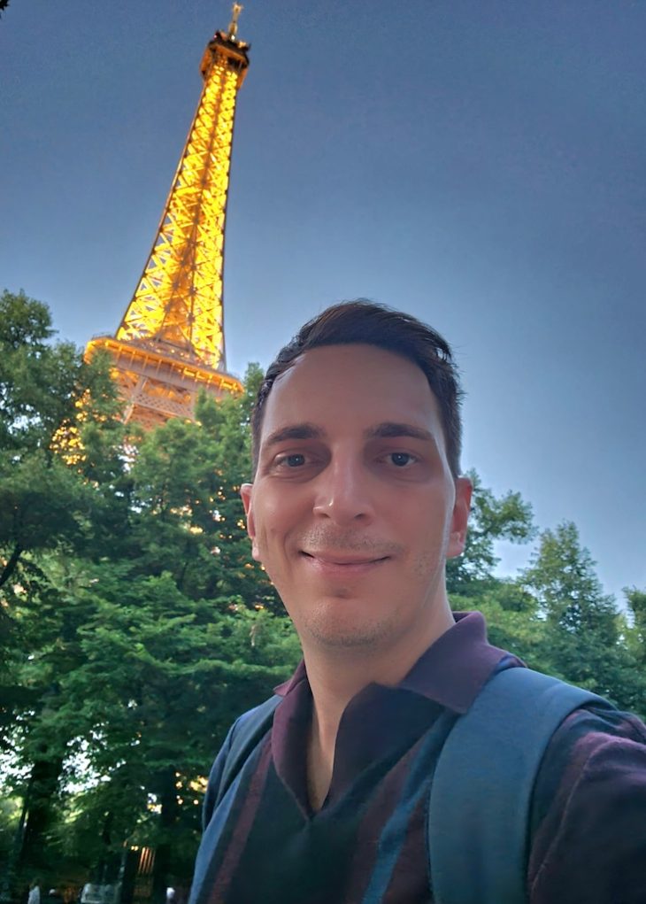Man poses for a selfie in front of the Eiffel Tower