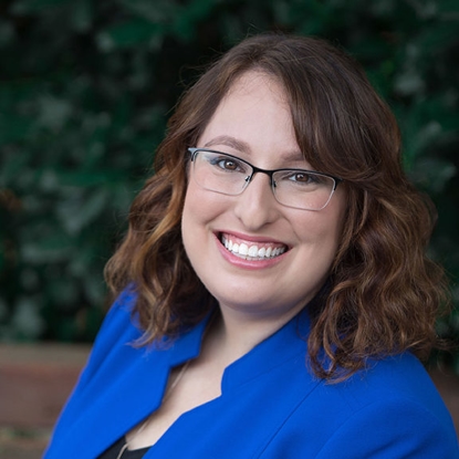 a woman in a blue suit smiling at the camera