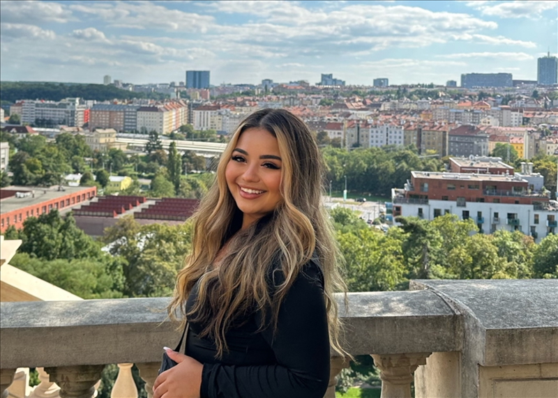 A woman smiles in front of a city skyline