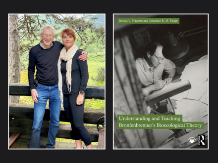 Two people stand smiling next to each other outdoors beside a photo of the book Understanding and Teaching Bronfenbrenner’s Bioecological Theory.