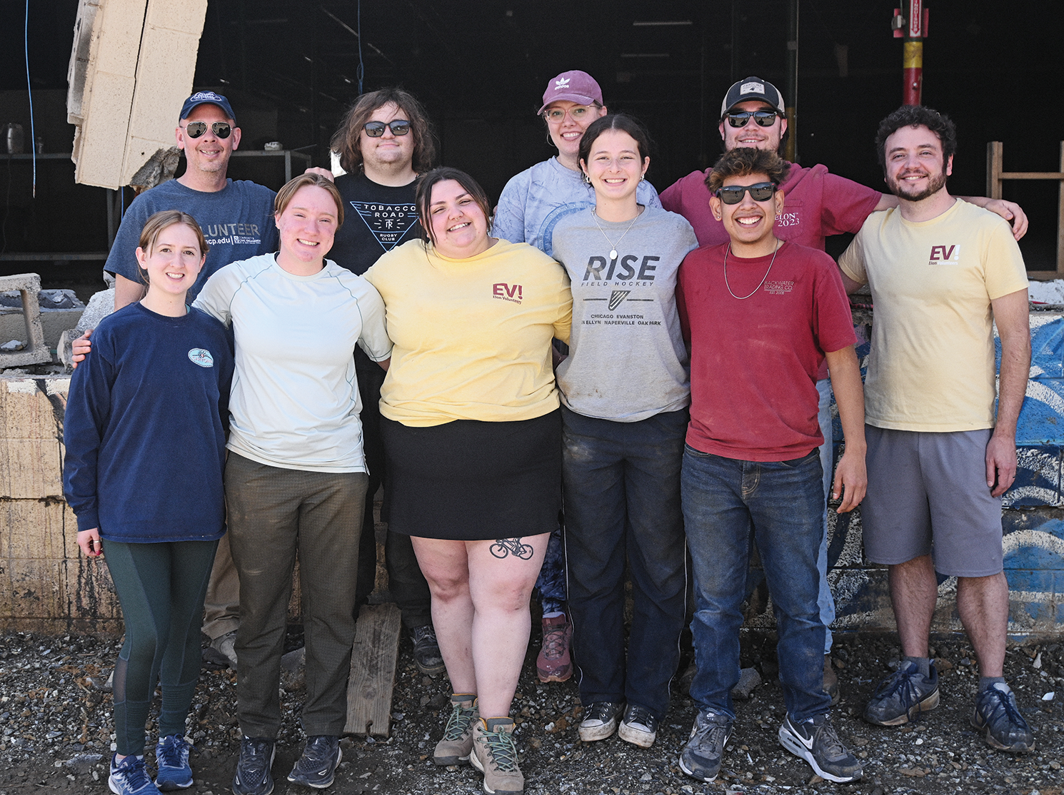 A group of volunteers pose for a photo with their arms around each other.