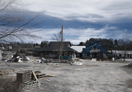 Gravel and debris surround a building damaged by a hurricane.