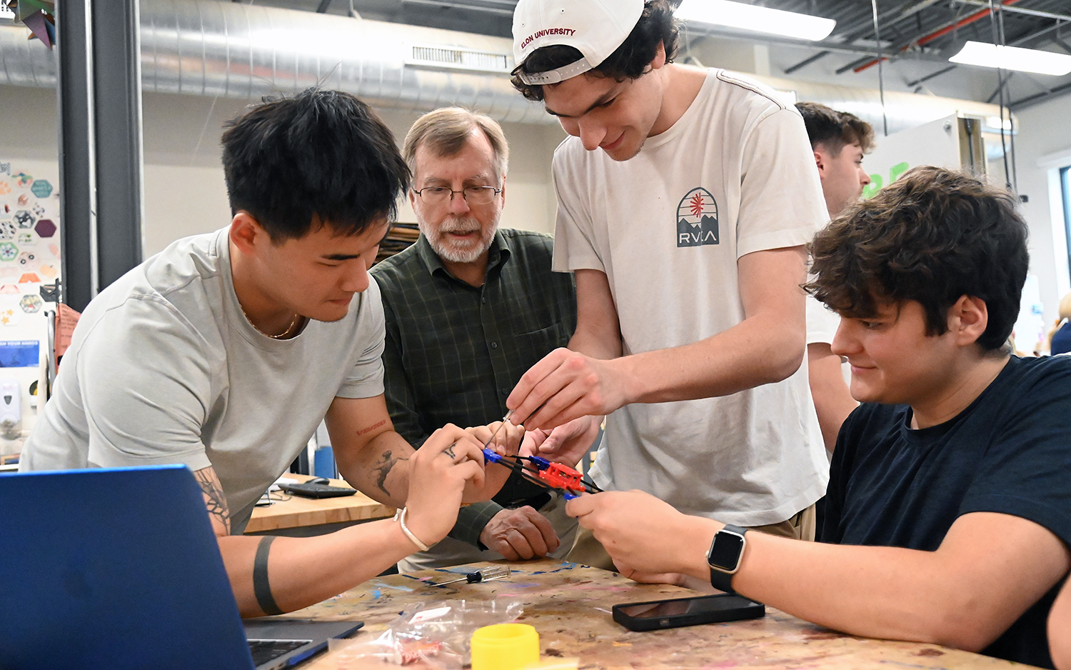 Elon professor Randy Piland surrounded by three male students