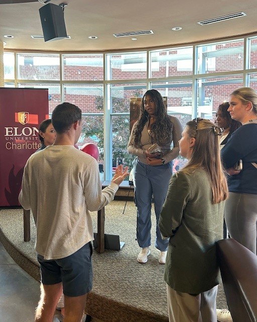 Several people talk with an Elon banner behind them