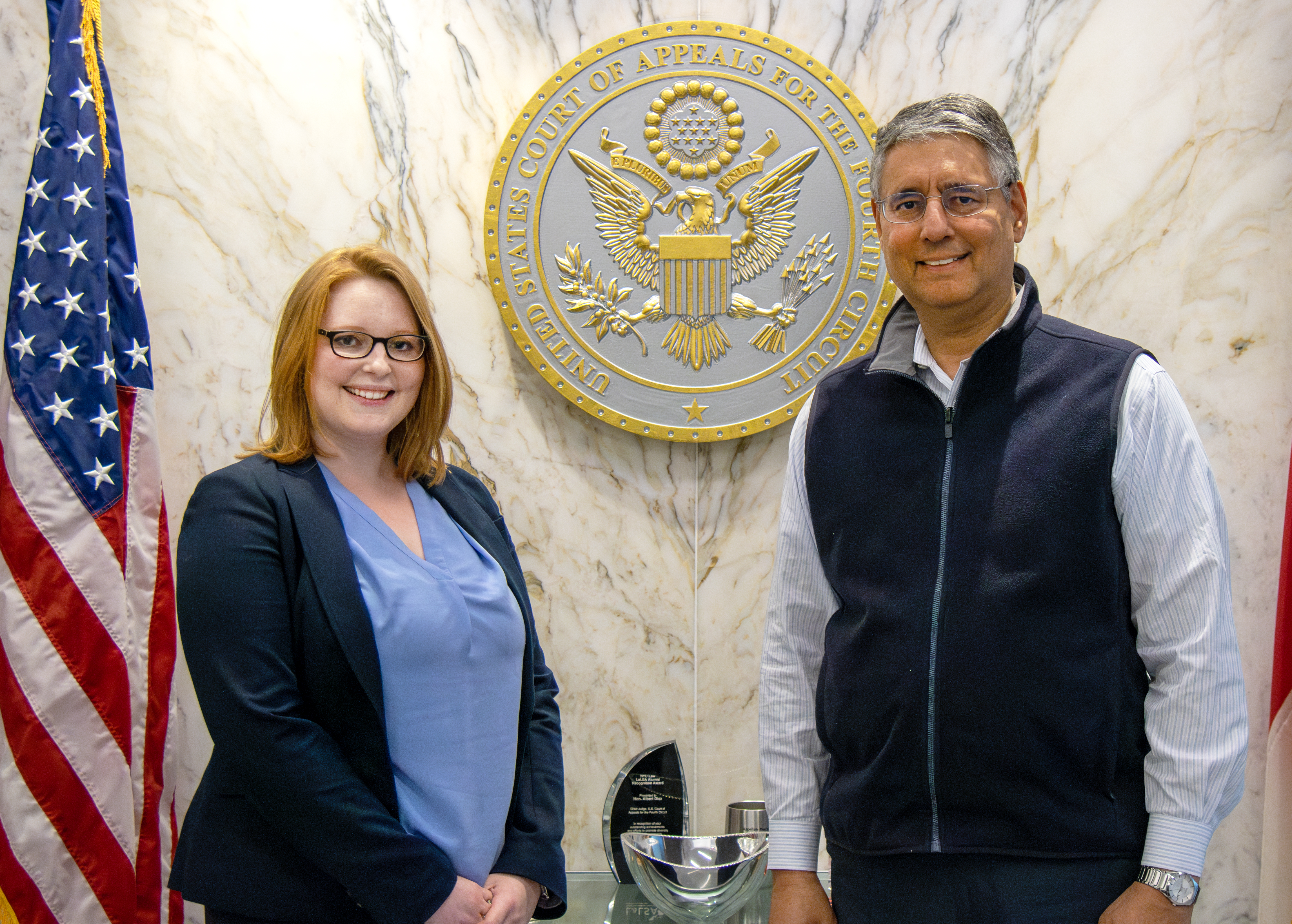 Ivey Schofield and Chief Judge Albert Diaz stand in front of the seal for the U.S. Court of Appeals.