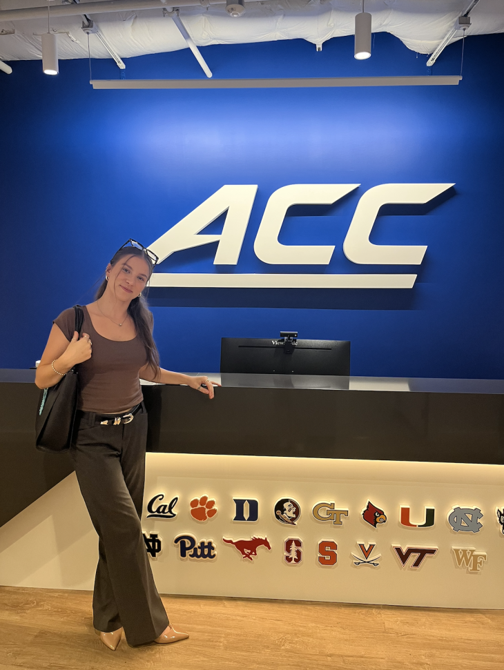 Skylar Cook ’28 poses infront of the ACC logo at her internship. 