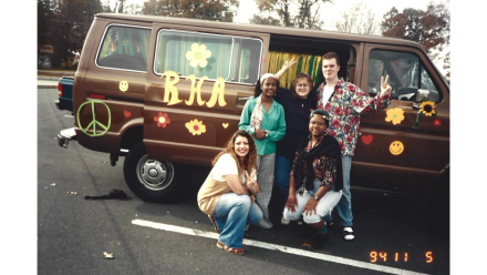 A group of college students in front of a brown van 