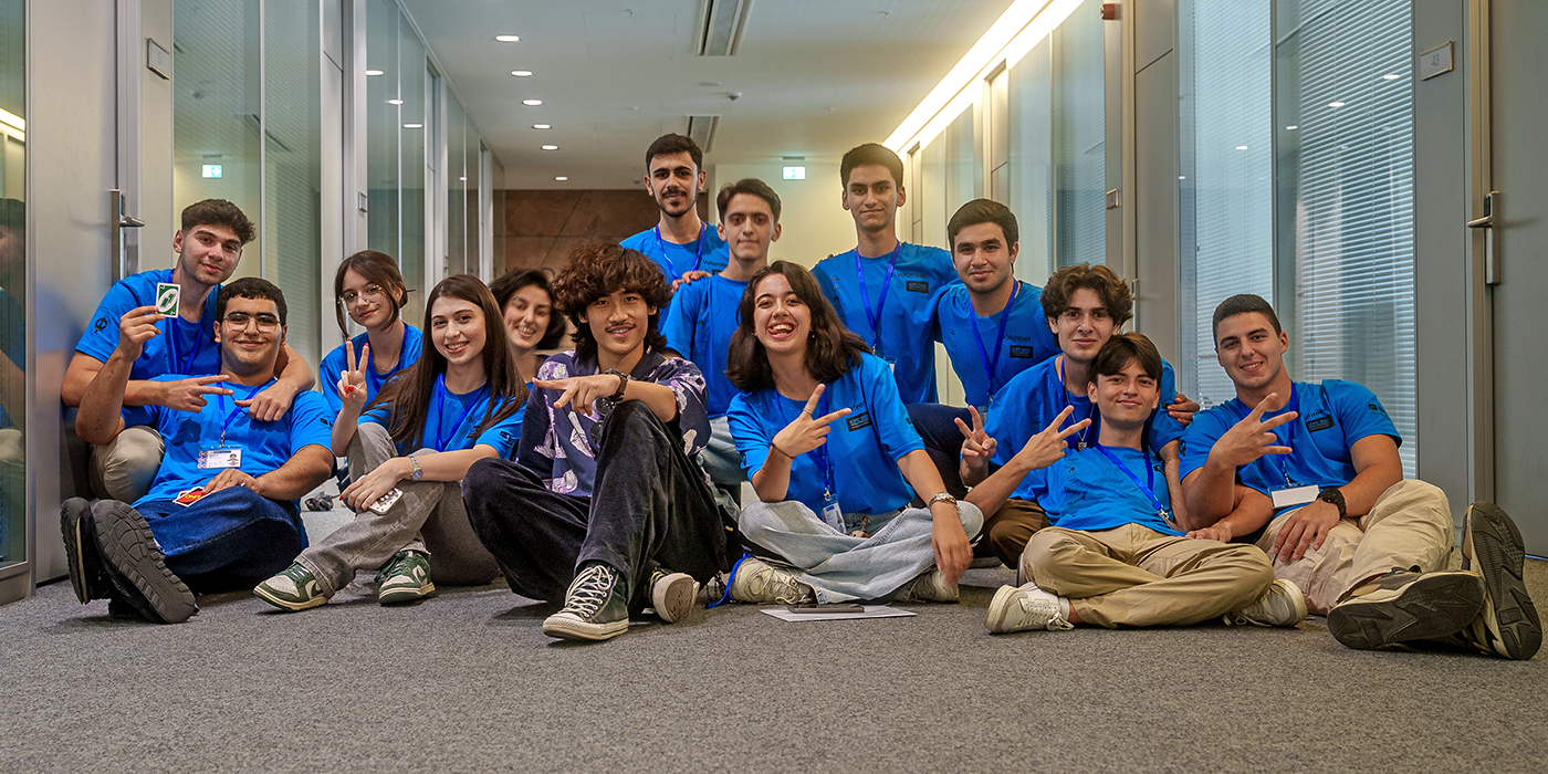 Ethan Wu ’27 sits with a group of young people at ICPC World Finals