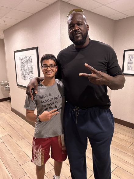 Sean Gansey, vestido de gris, posa con un signo de la paz junto a Shaquille O'Neal, vestido de negro.