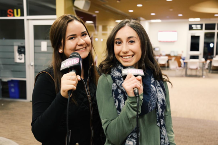 Carmencita Rosales, left, and Kristina Piersanti '19, right, pictured smiling and holding microphones while working for ETalk in 2018.