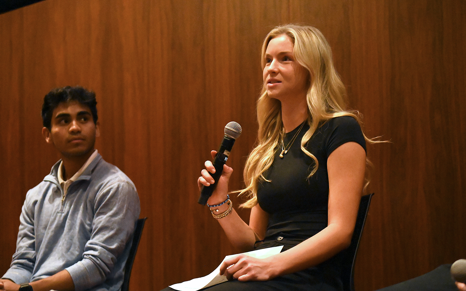 Lily Barker '25 holds a microphone at Elon Sport Management event.