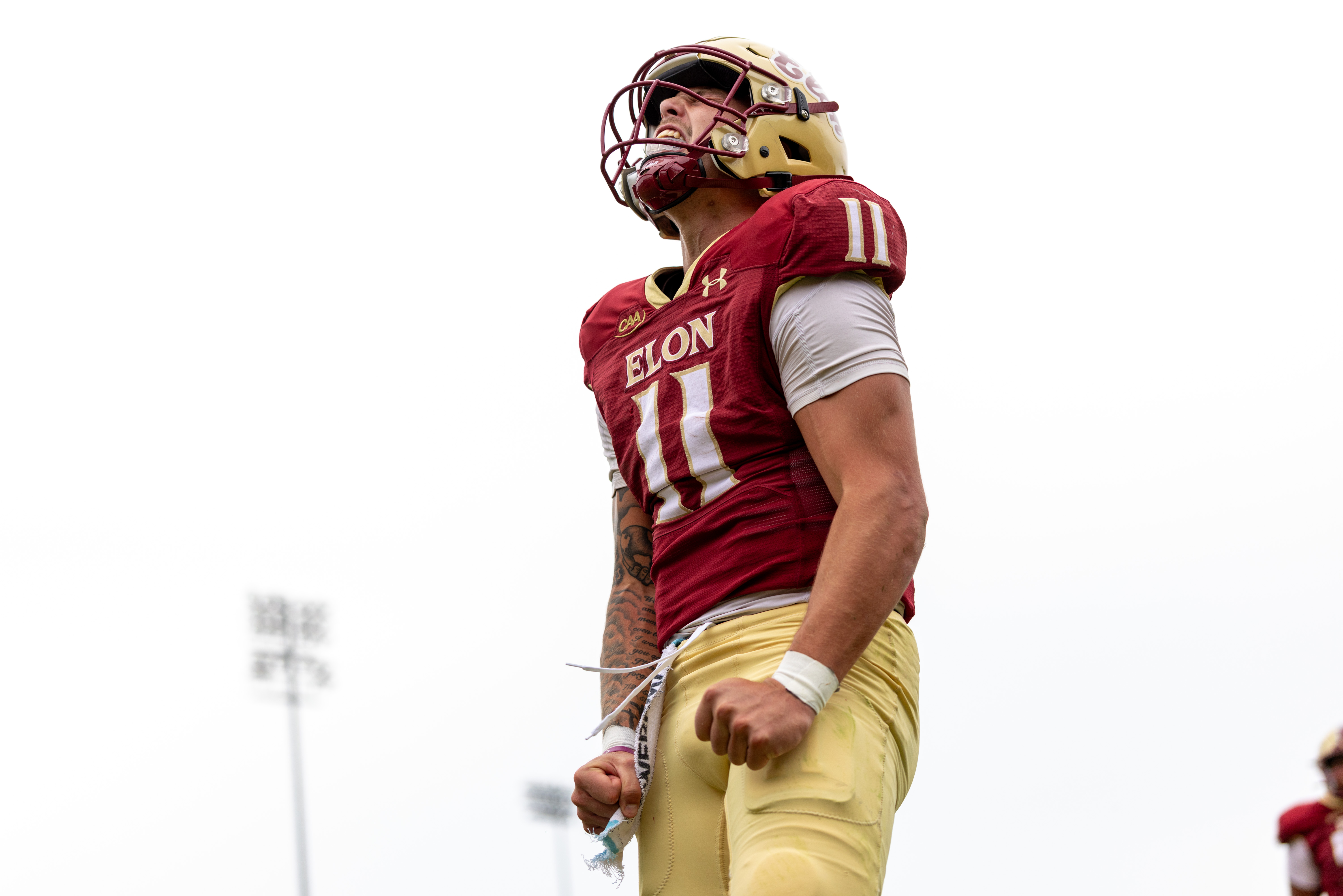 A football player screams to the air with his arms by his side