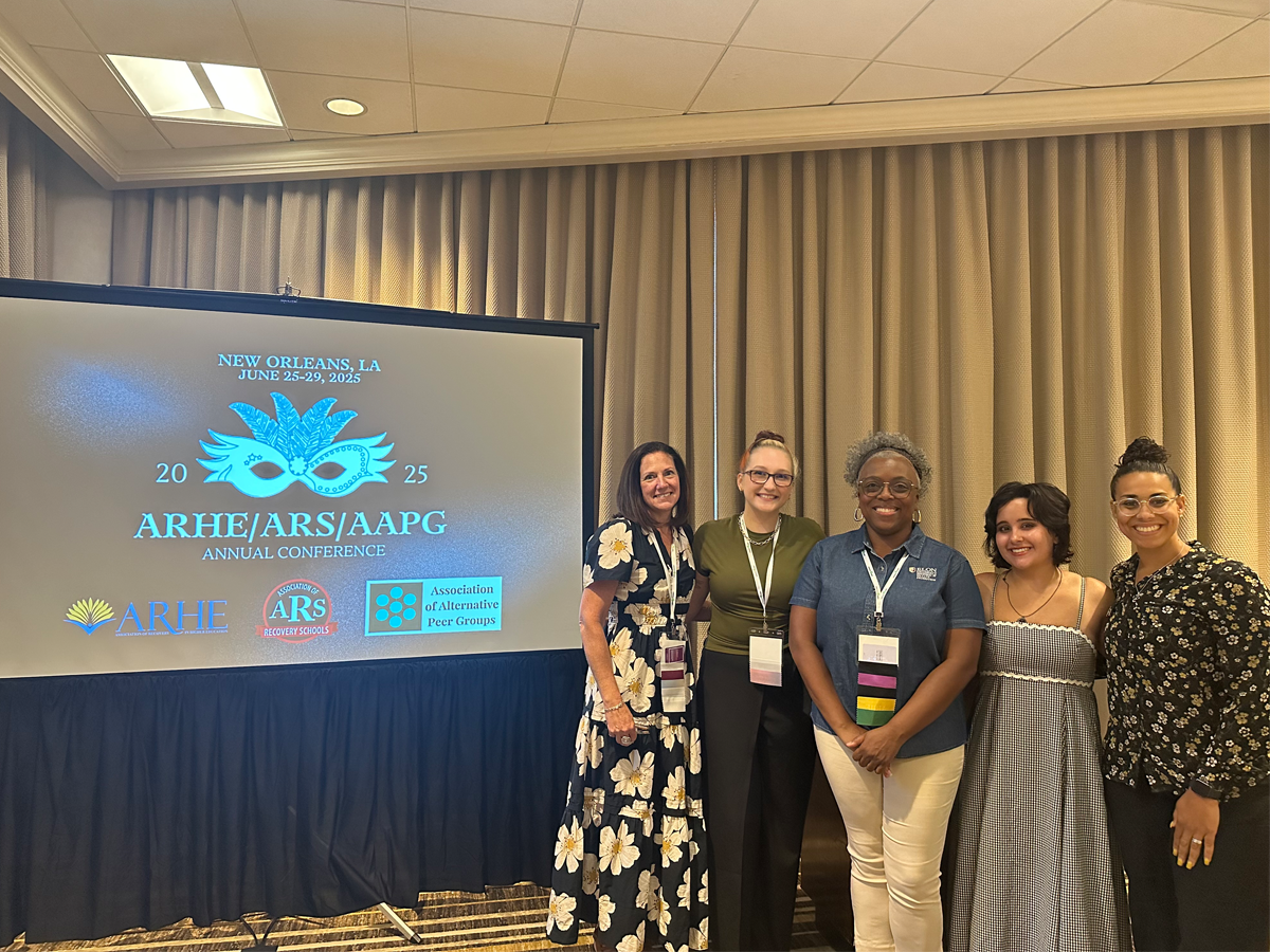 A group of five conference presenters smiles for a photo in front of a projection screen displaying “ARHE/ARS/AAPG Annual Conference, New Orleans, LA, June 25–29, 2025.” The participants wear name badges and stand together in a warmly lit conference room, reflecting a collaborative and professional atmosphere.