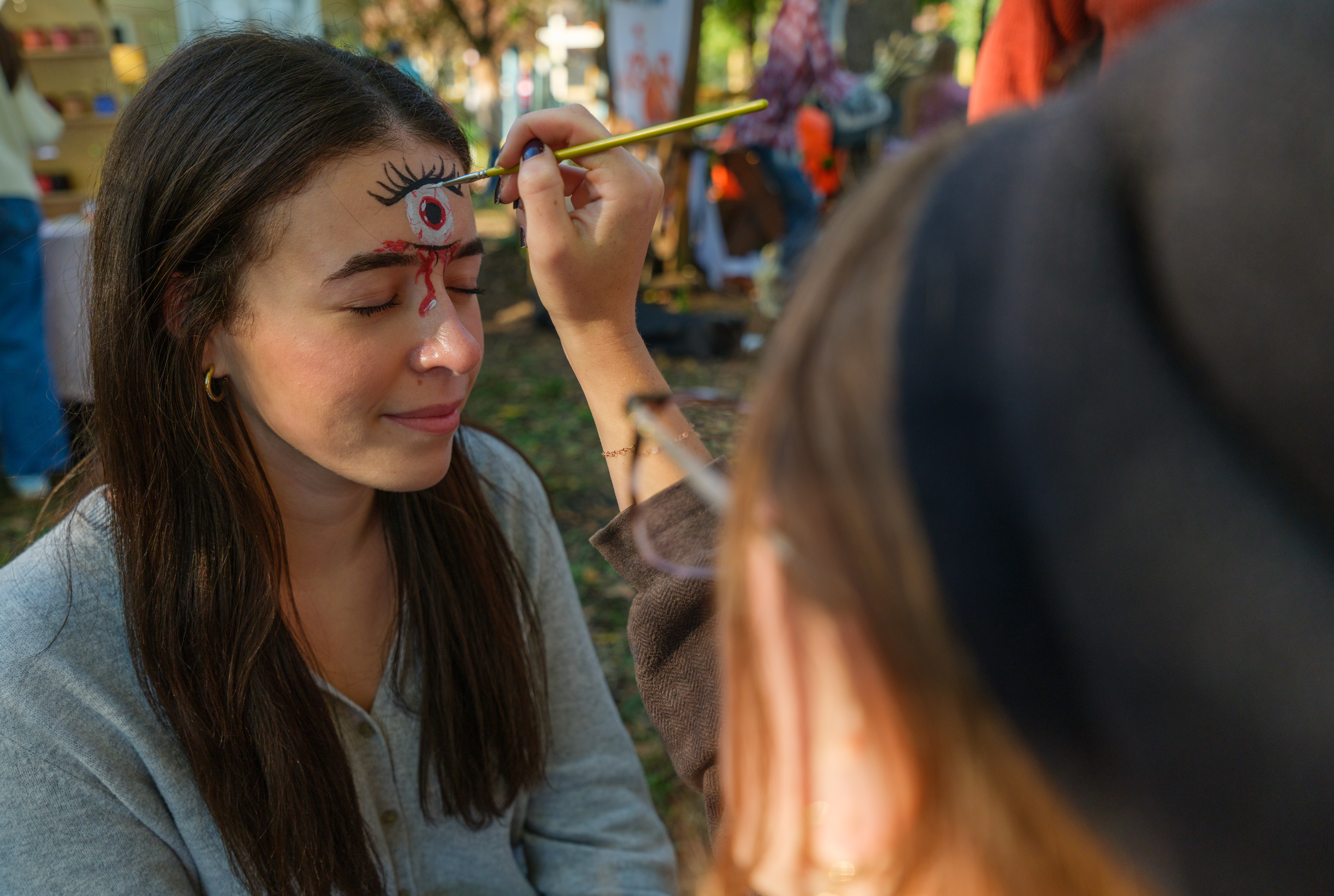 A person has an eye painted on their forehead