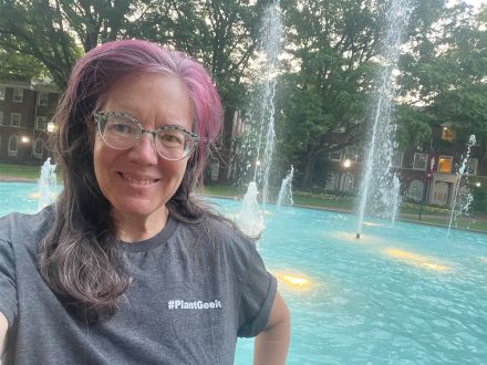 Woman poses for photo in front of fountain