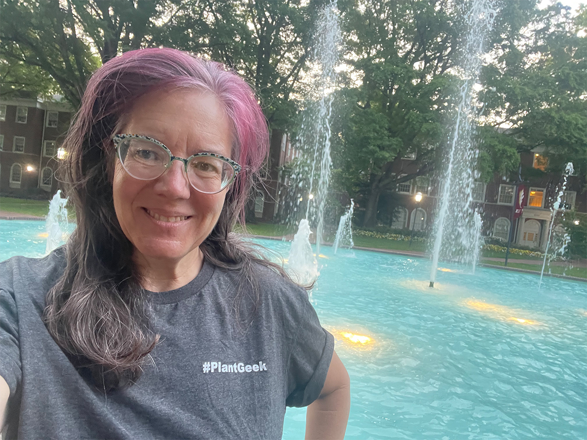 Woman poses for photo in front of fountain