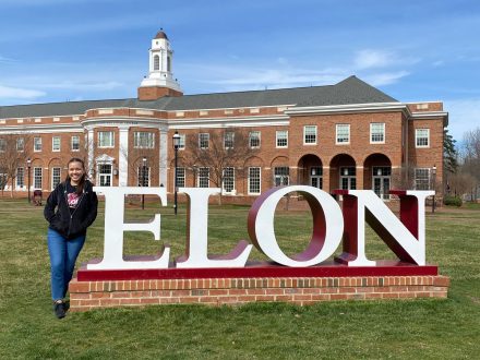 Malia Cortes stands in front of the Elon sign