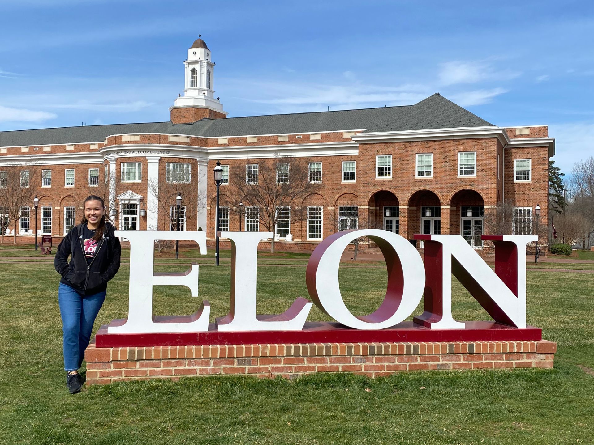 Malia Cortes stands in front of the Elon sign