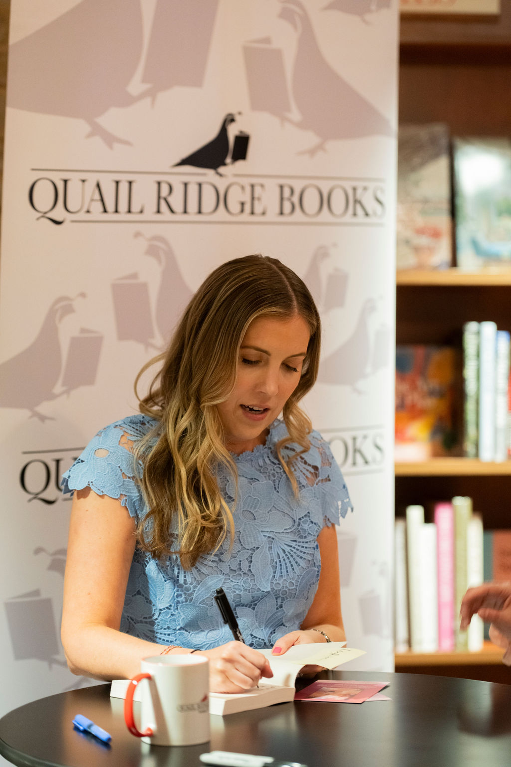 An author signs a copy of a book