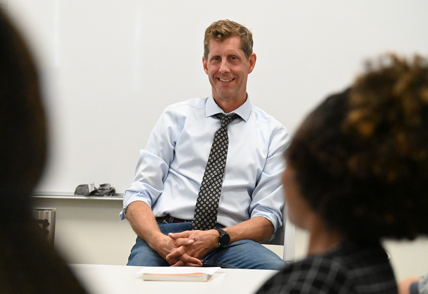 Phillip Motley sits in front of an Elon classroom.