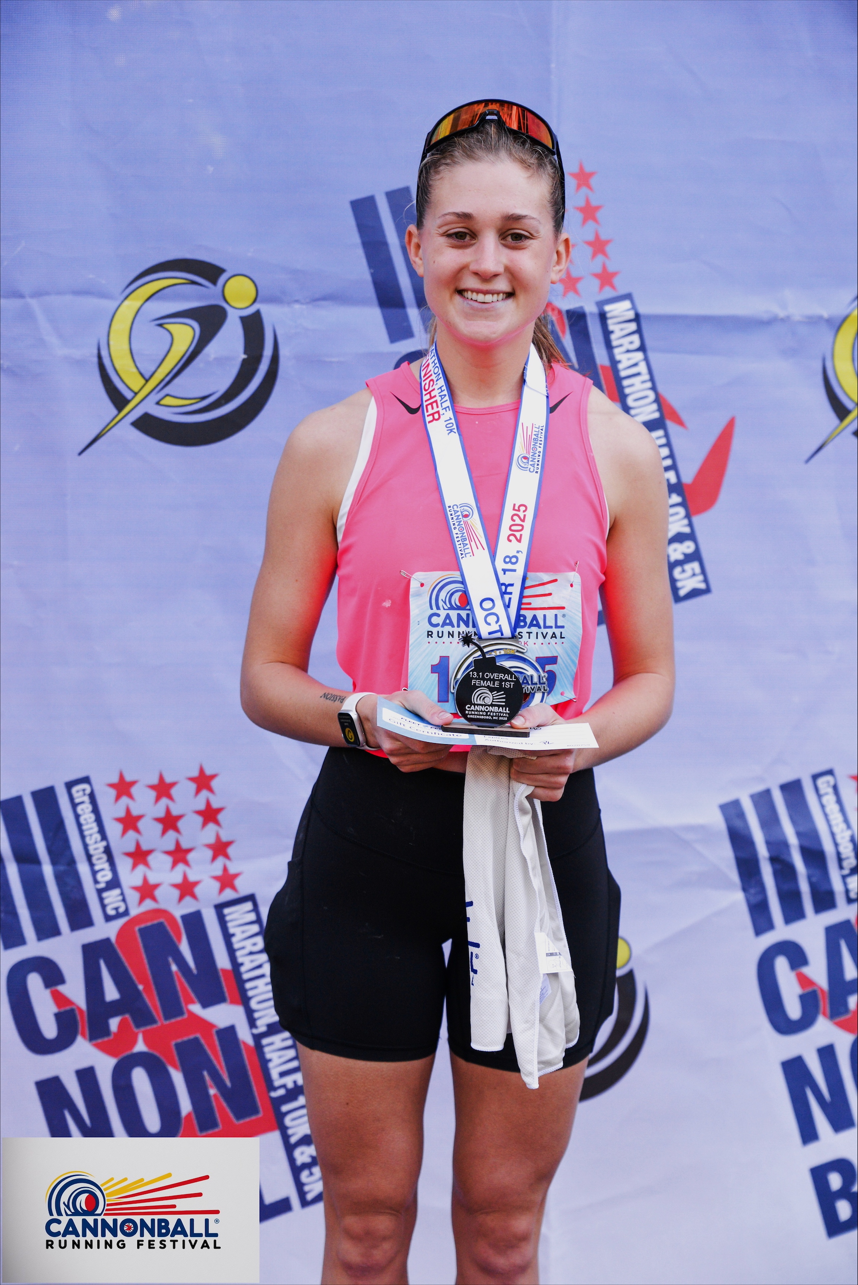 Abbi Morrell holds a trophy and wears a medal from the Greensboro Half Marathon