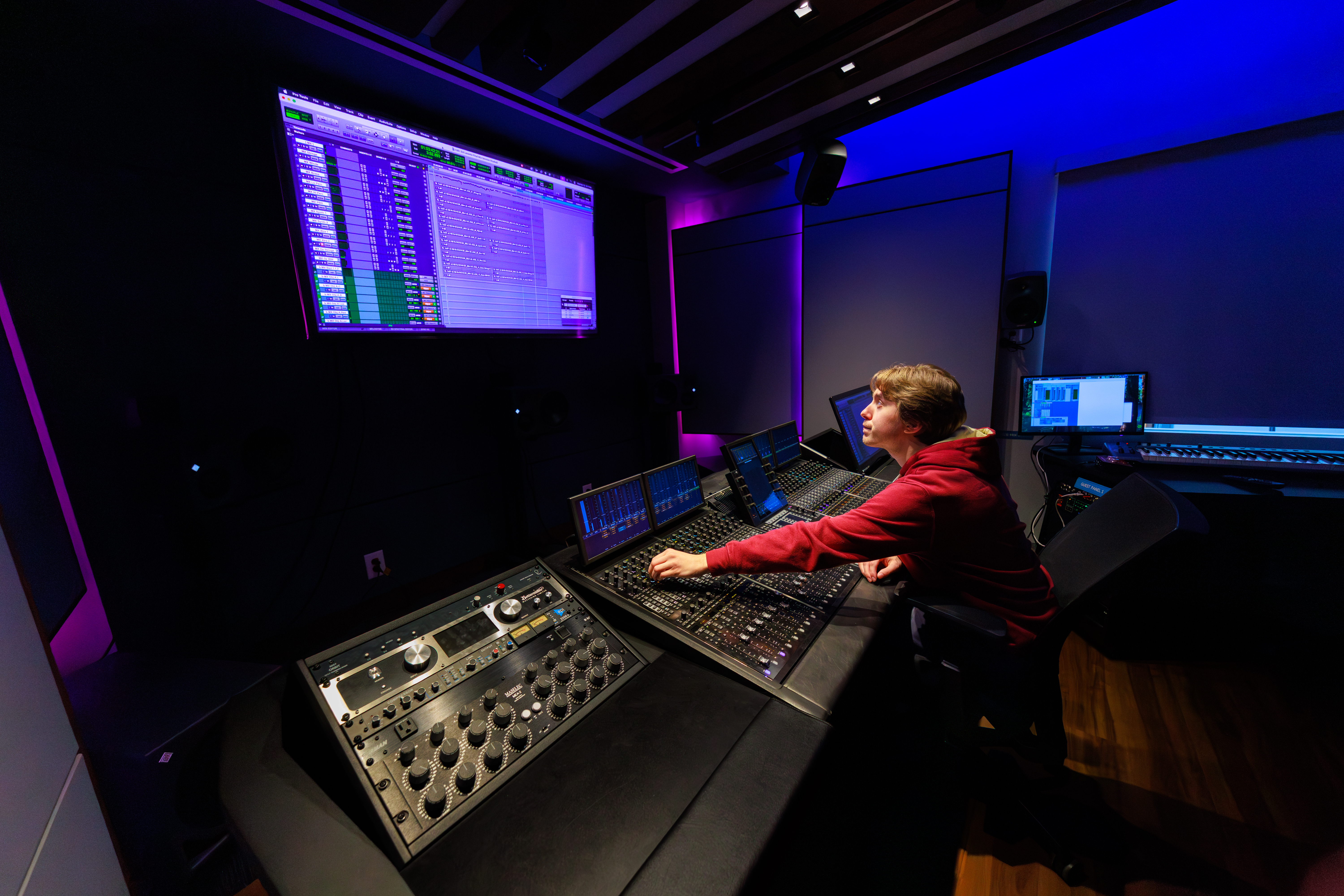 A person works on a sound board in a dark room