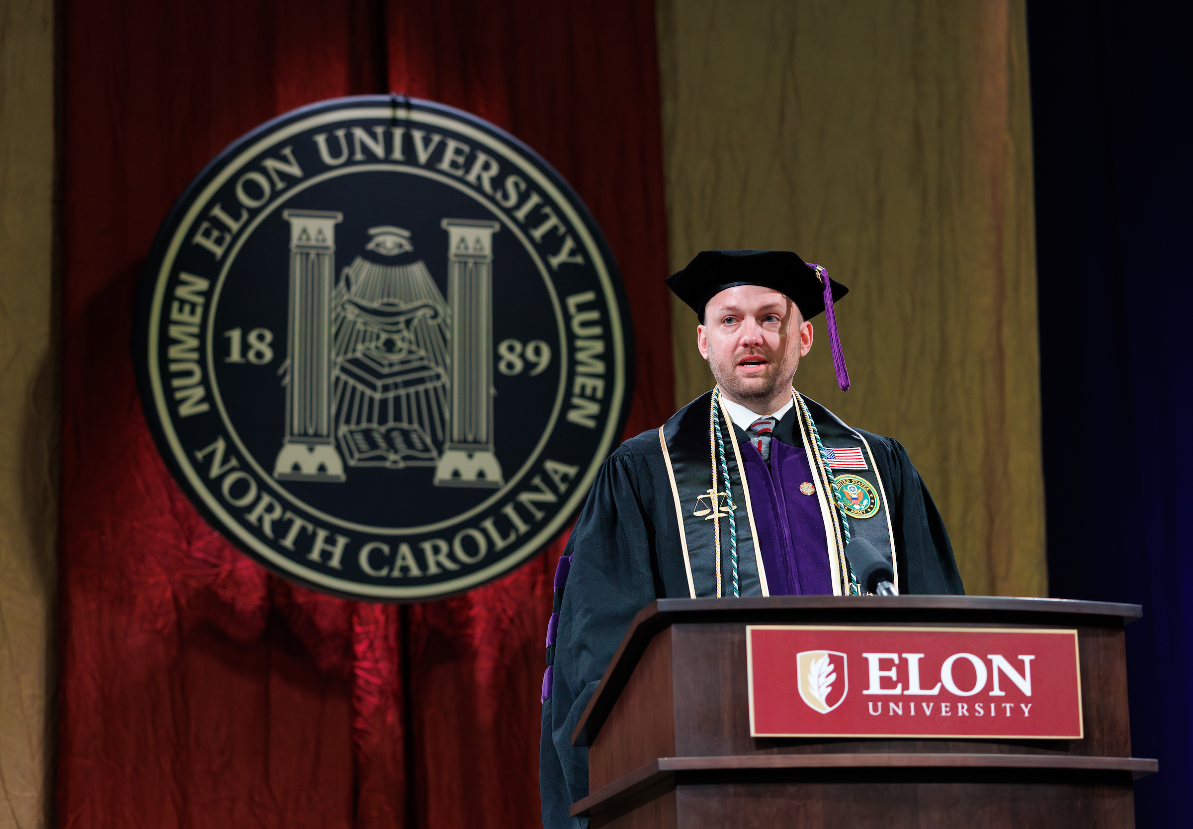 A male student behind a podium that says Elon University.