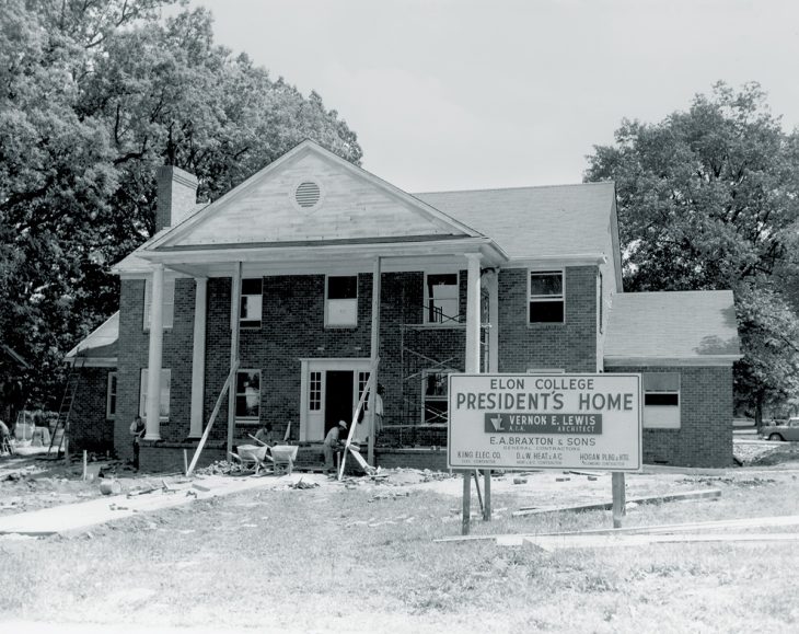 A black-and-white photograph shows the construction of the Elon College president’s home, with workers and scaffolding visible.
