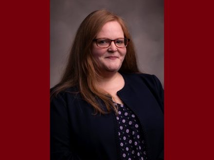 Headshot of Shannon Duvall. She is red hair and is wearing a black blazer with a polka dot blouse