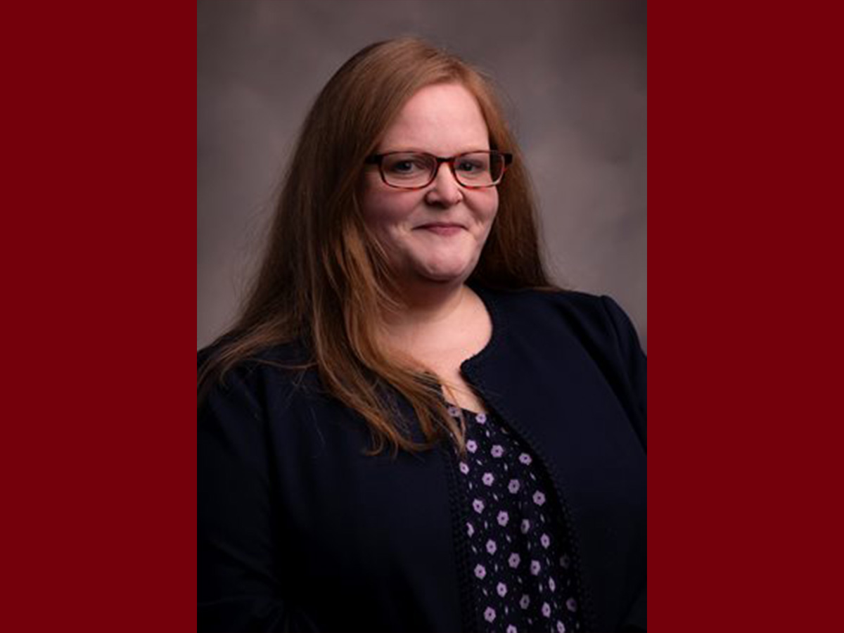 Headshot of Shannon Duvall. She is red hair and is wearing a black blazer with a polka dot blouse
