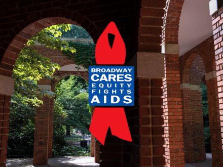A brick archway walkway surrounded by greenery is shown with the red ribbon logo and text reading “Broadway Cares / Equity Fights AIDS” centered in the image. The logo stands out against the historic brick architecture and leafy outdoor setting.