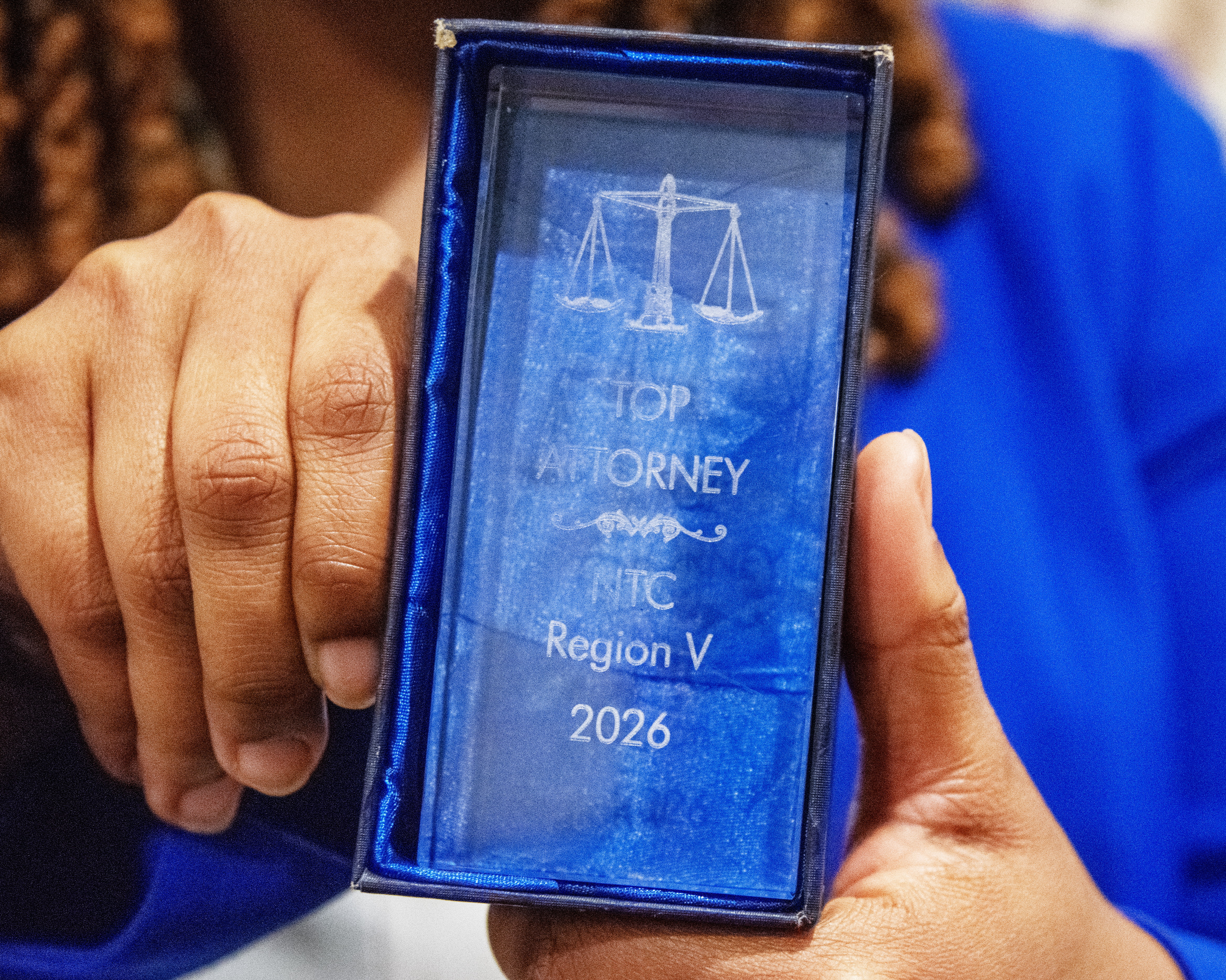 Closeup of a translucent award plaque that reads "Top Attorney NTC Region V 2026"