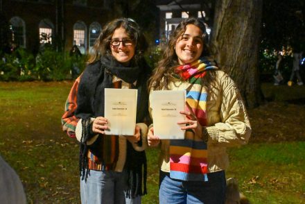 Two students pose with plastic luminaries.