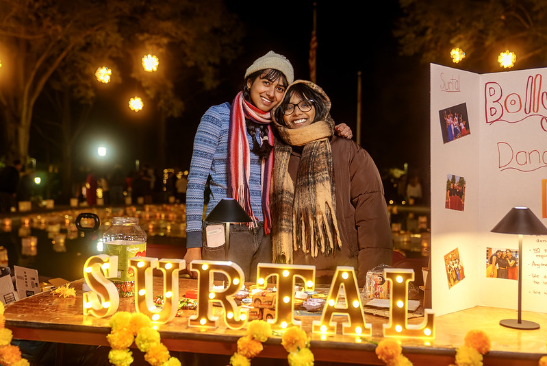 Two students at a program table.