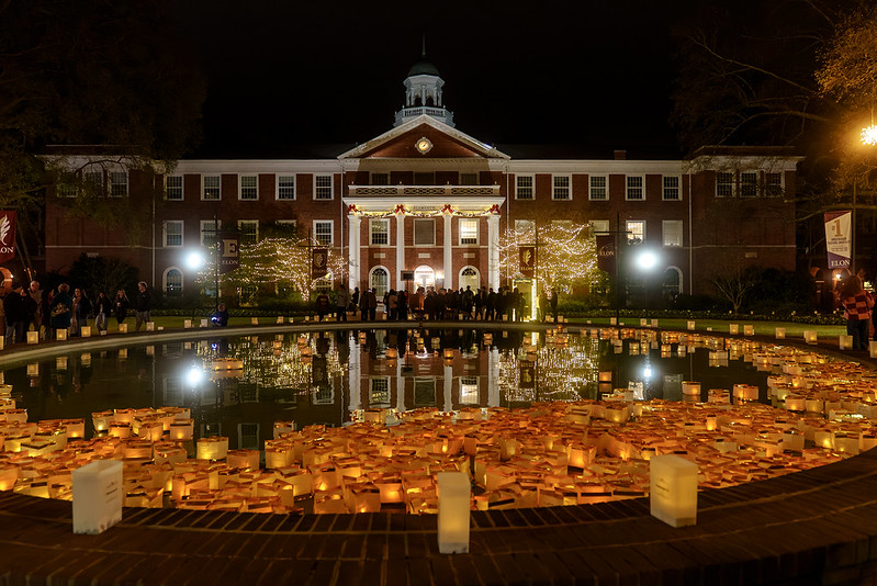 Floating lanterns in a fountain with luminaries on the fountain wall.