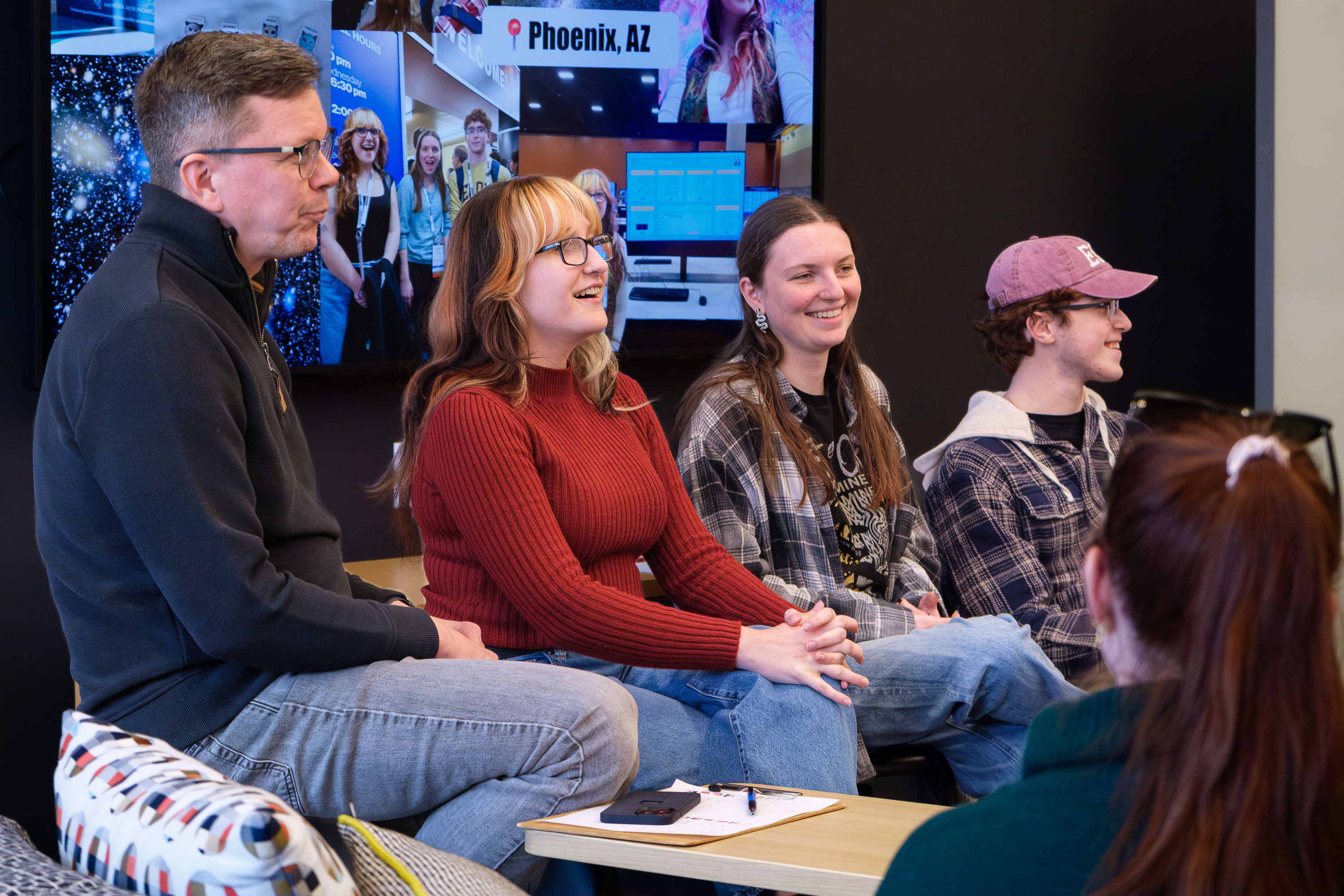Four people sit next to each other on a panel