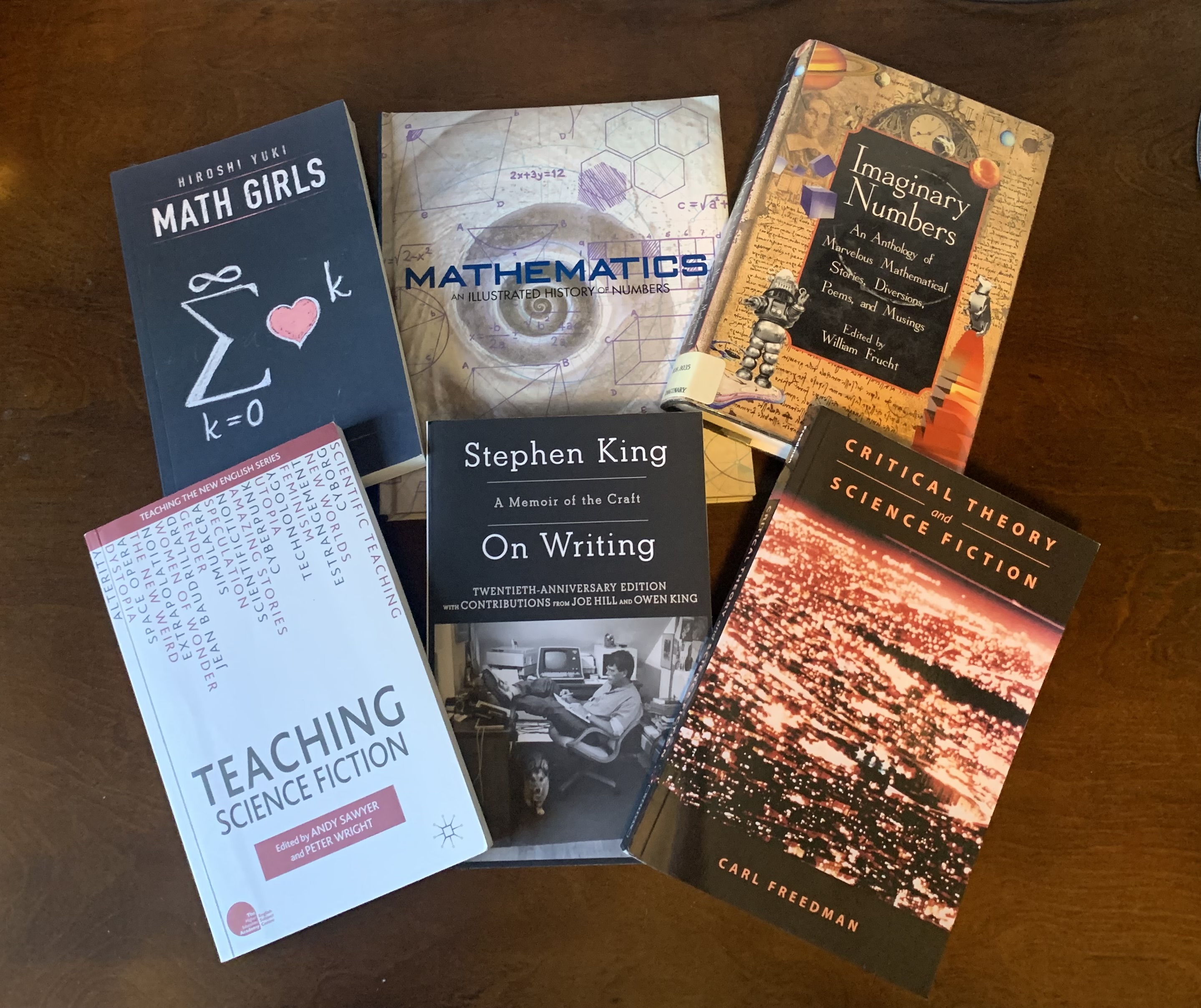 Six mathematical fiction book covers displayed on a table.